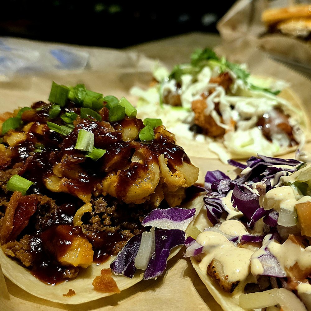 Three BTW tacos with slaw, cabbage, and sauce